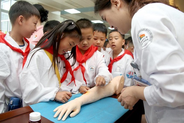 往屆活動中，小醫(yī)生們在醫(yī)護(hù)人員的指導(dǎo)下學(xué)習(xí)傷口消毒及包扎。重醫(yī)附屬大學(xué)城醫(yī)院供圖