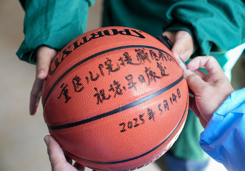 手術(shù)后，醫(yī)生為洛桑羅布送上籃球。 重慶醫(yī)科大學(xué)附屬兒童醫(yī)院供圖