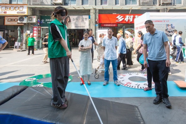 市民戴眼罩沉浸式體驗(yàn)盲人行走。渝北殘聯(lián)供圖
