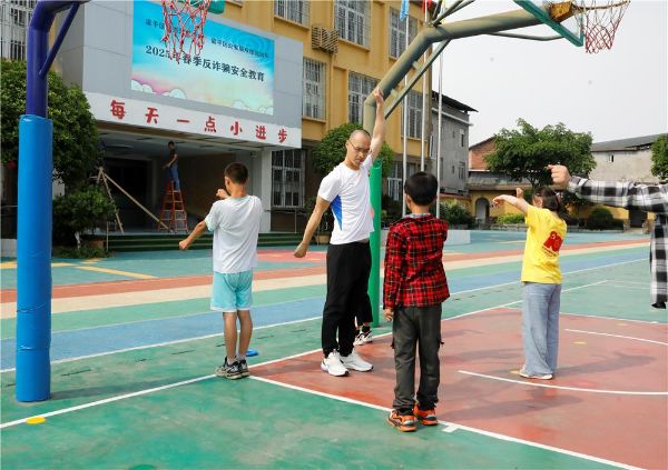 黃鷹帶領(lǐng)孩子們鍛煉。譚燕攝