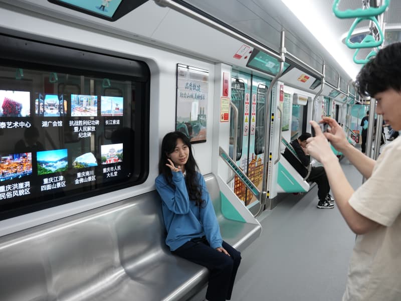 乘客打卡重慶軌道交通18號(hào)線智慧車窗。謝茂攝