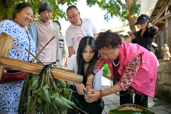 游客在當?shù)鼐用竦闹笇掳兆印t虢瓍^(qū)委宣傳部供圖