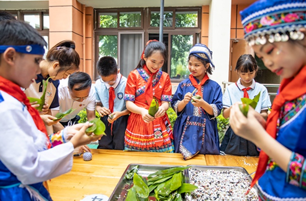各民族學(xué)生一起包五色粽，共度端午佳節(jié)。劉紀(jì)湄?cái)z