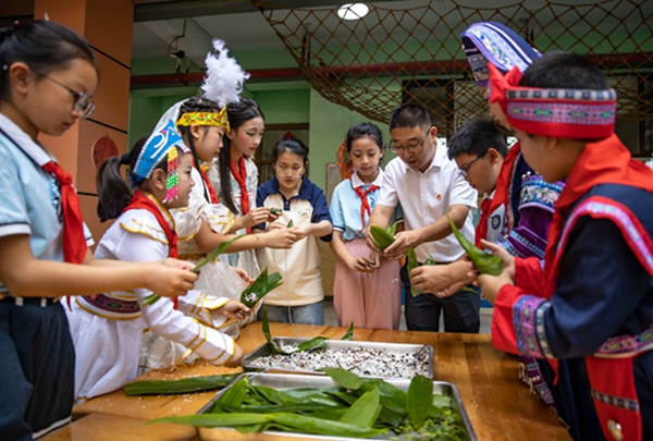 各民族學(xué)生一起包五色粽，共度端午佳節(jié)。劉紀(jì)湄?cái)z