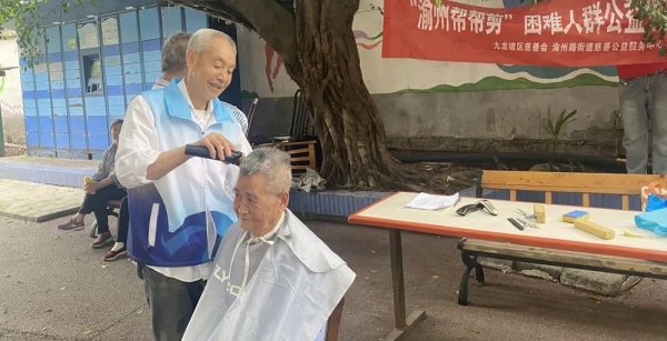 “銀發(fā)剪刀手”張禎祿正在為一坪小區(qū)居民提供義剪服務。廖婉廷攝