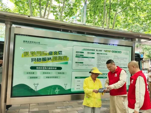工作人員在公交站臺為市民宣傳科學(xué)用電知識。張強攝