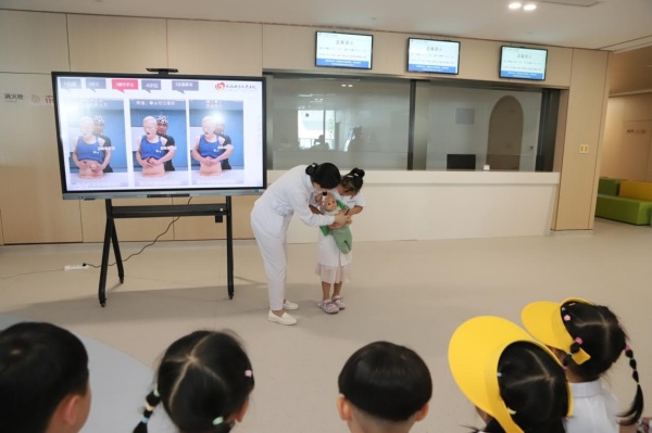 萌娃在醫(yī)院工作人員的指導(dǎo)下學(xué)習(xí)海姆立克急救方法。趙海攝