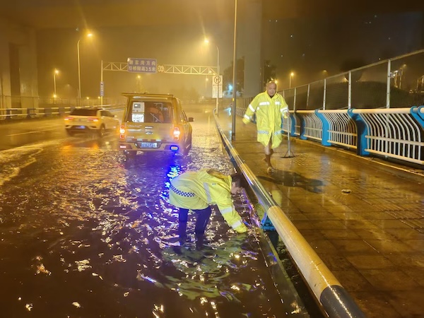 排水工作人員正在進(jìn)行積水處置。重慶市住房城鄉(xiāng)建委供圖