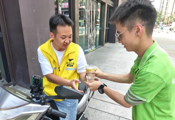 “小電潼”為外賣騎手遞上檸檬水。重慶電力高等?？茖W(xué)校供圖