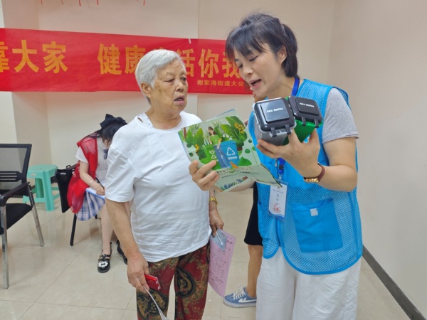 工作人員通過垃圾分類彩頁、模型等向老年人講解垃圾分類知識。呂麗珊攝