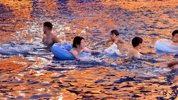 游客在晚霞映照的水面戲水。景區(qū)供圖