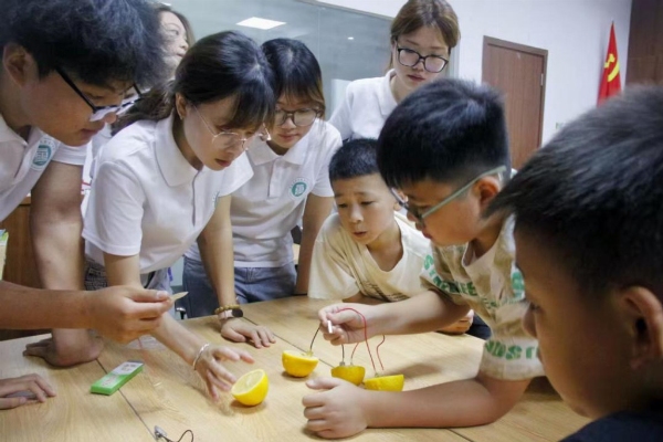 踐行團(tuán)成員指導(dǎo)小朋友進(jìn)行水果發(fā)電實(shí)驗(yàn)。重慶電力高等專科學(xué)校供圖