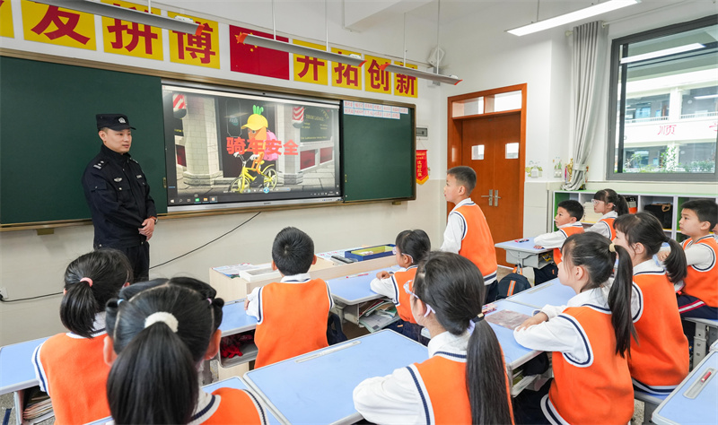桂陽街道民警為西湖小學(xué)的學(xué)生講解交通安全。墊江縣融媒體中心供圖 第1眼TV-華龍網(wǎng)發(fā)