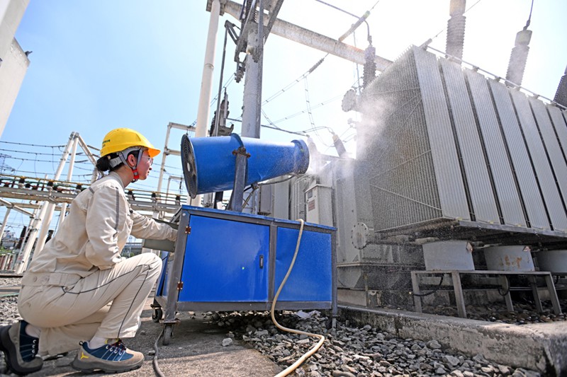 高溫天氣下，國網(wǎng)重慶市北供電公司運(yùn)維人員在220千伏大竹林變電站用水炮對變壓器進(jìn)行降溫。向江微攝