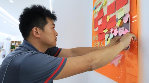 快遞小哥將心愿貼上“騎士心愿墻”。楊妮沙攝