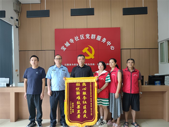 居民廖先生為寶城寺社區(qū)民警、網(wǎng)格員送錦旗致謝。通訊員 王軒 攝