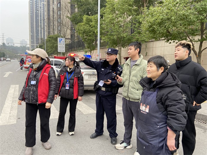 社區(qū)民警、網(wǎng)格員與居民現(xiàn)場查看處置機(jī)動車占道停放堵塞消防通道問題。通訊員 王軒 攝