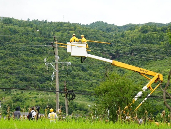 媒體記者在綦江區(qū)東溪鎮(zhèn)拍攝供電員工引流線搭接工作。袁巧攝