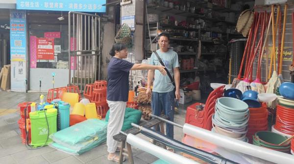 張欽庭規(guī)勸占道經(jīng)營的攤主。東溫泉鎮(zhèn)供圖