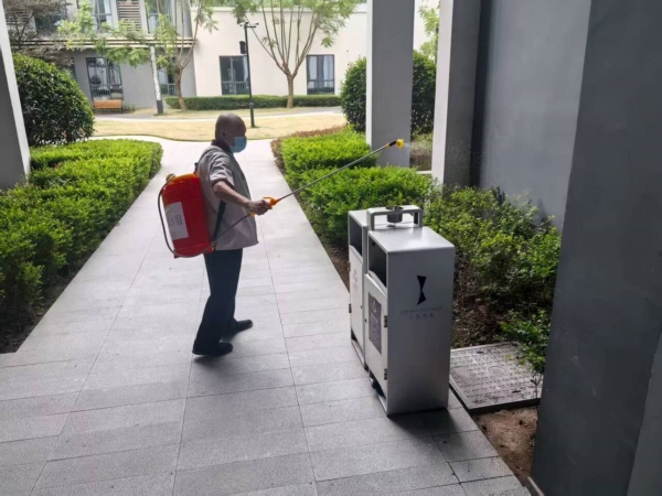 環(huán)衛(wèi)人員背著消殺設(shè)備對重點部位噴灑消毒藥劑。劉琴攝