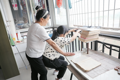 李遇梅攥著女兒僵硬的身體不斷練習(xí)下蹲。楊青攝