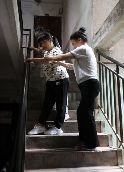 李遇梅正扶著女兒下樓。趙英如攝