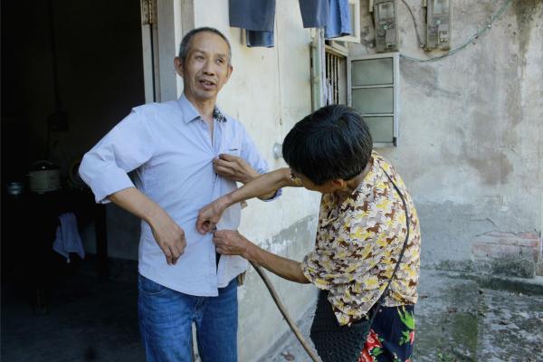 銀齡志愿者為老人整理衣服。鄒冰倩攝