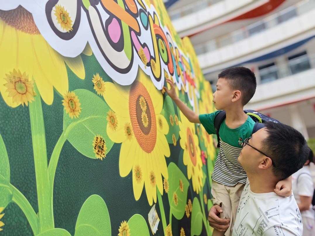 北碚區(qū)兩江春暉小學(xué)一年級(jí)新生在“葵花墻”上貼上小心愿。周輝攝
