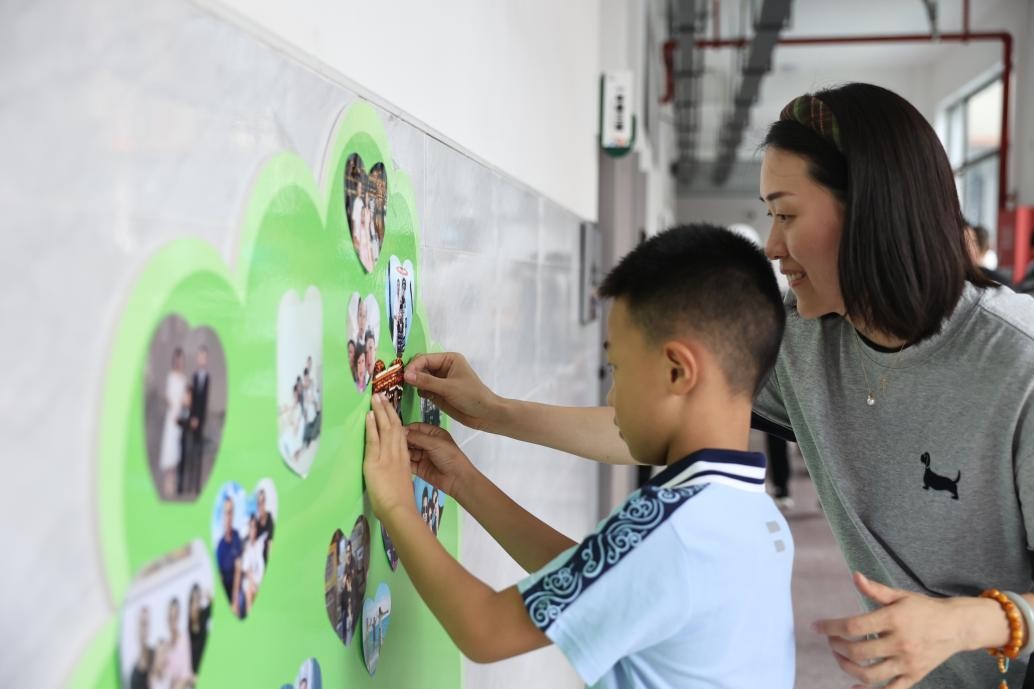 勉仁小學(xué)一年級(jí)新生在成長(zhǎng)樹(shù)上貼全家福。晏瀅瀅攝