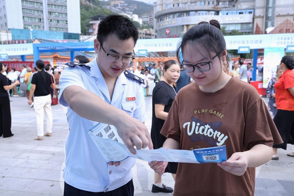 奉節(jié)縣稅務人員在公平競爭政策宣傳活動現場向市民宣傳納稅信用管理相關政策。孫艷嬌攝