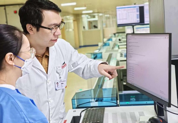 實(shí)驗(yàn)室工作人員與工程師討論系統(tǒng)內(nèi)容調(diào)整。重慶醫(yī)科大學(xué)附屬第三醫(yī)院（方大醫(yī)院）供圖