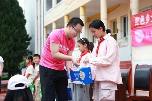 工作人員給學(xué)生捐贈(zèng)牛奶。天友乳業(yè)供圖