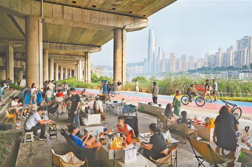 十月五日，江北區(qū)北濱路步道，市民正在休閑露營(yíng)。國(guó)慶假期，市民在這里或騎行賞景，或休閑玩耍，在戶(hù)外享受輕松愜意的假期時(shí)光。首席記者 龍帆 攝\視覺(jué)重慶