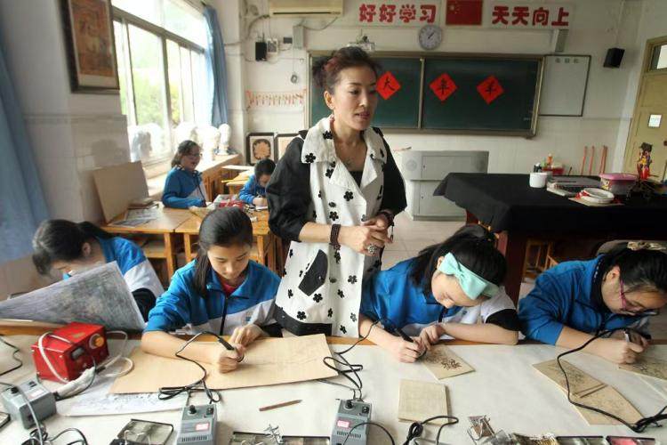 高磊老師在指導學生制作烙畫。