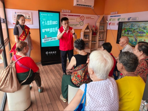 招商銀行重慶分行員工在“紅金渝”忠恕沱社區(qū)金融網(wǎng)格驛站為老年人普及金融知識。招商銀行重慶分行供圖