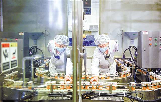 天友乳業(yè)生產(chǎn)車間，全自動利樂冠灌裝機(jī)前，工作人員在查看產(chǎn)品品質(zhì)。（資料圖片） 記者 萬難 攝視覺重慶