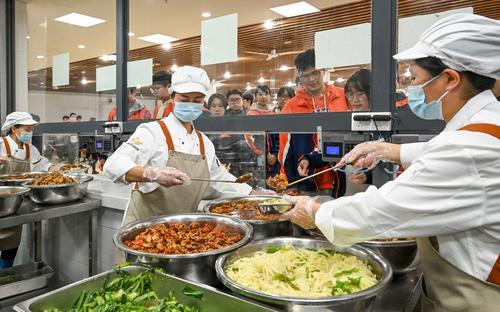 10月29日，位于兩江新區(qū)的兩江育才中學校，工作人員在食堂售賣廳為學生們盛飯菜。記者 張錦輝 攝/視覺重慶