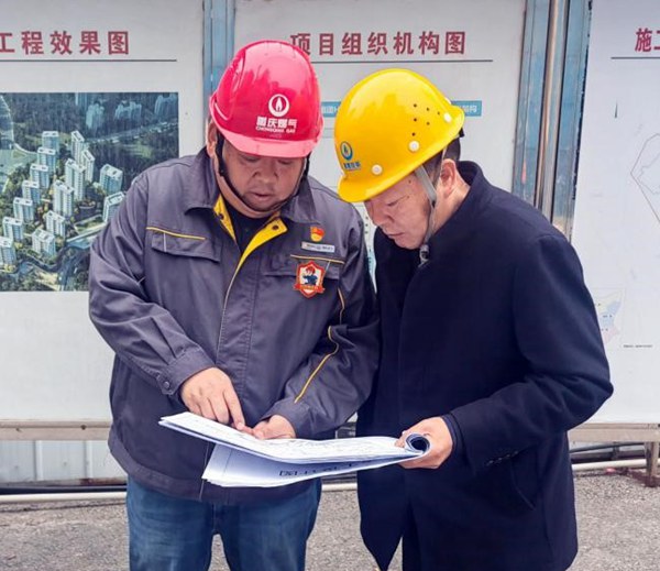 “紅巖燃小兵”服務(wù)先鋒隊(duì)隊(duì)員與施工班組負(fù)責(zé)人共同研討施工圖紙，細(xì)化施工銜接要點(diǎn)。重慶燃?xì)饧瘓F(tuán)供圖